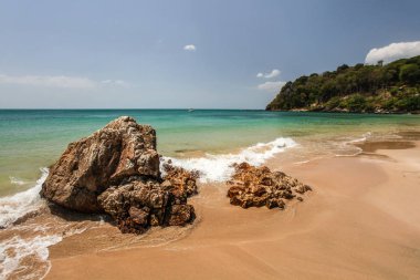 Kayalar ön planda ve yeşil mavi denizde Klong Nin beach 