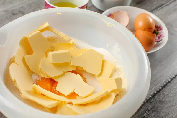 Белая пластиковая миска с маслом, яичные желтки и сахар смешанные - подготовка — стоковое фото