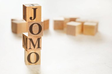 Dört ahşap küp üst üste dizilmiş metin Jomo 'nun anlamı onları kaçırmanın sevinci, sağ alt köşede metin resmi için boşluk