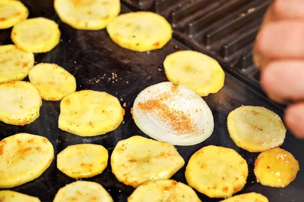 Rebanadas de patatas y cebolla sazonada con especias a la parrilla en la parrilla eléctrica, foto de primer plano —  Fotos de Stock