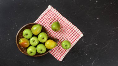 Üst aşağı manzara, yeşil elma ve armutlar ahşap oyulmuş kasede, kırmızı