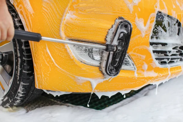 Paraurti anteriore e fanali di auto gialla lavati in self serve carwa — Foto Stock