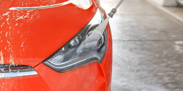 Faro delantero del coche rojo lavado en auto servicio de lavado de coches, alta pr — Foto de Stock