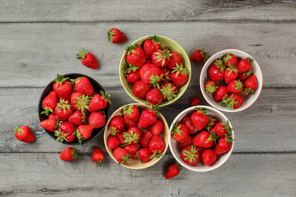 Vista de la mesa - cinco cuencos pequeños con fresas, algunos de ellos — Foto de Stock