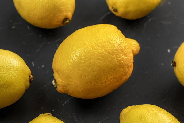 Top view - whole lemons on black marble board. — Stock Photo, Image