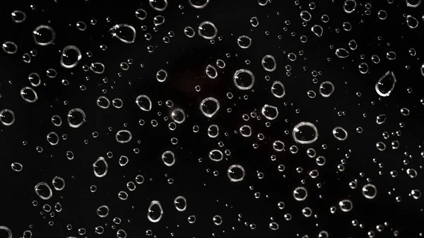 Tutup - tetes air hujan di balik kaca terlihat seperti gelembung di bla — Stok Foto