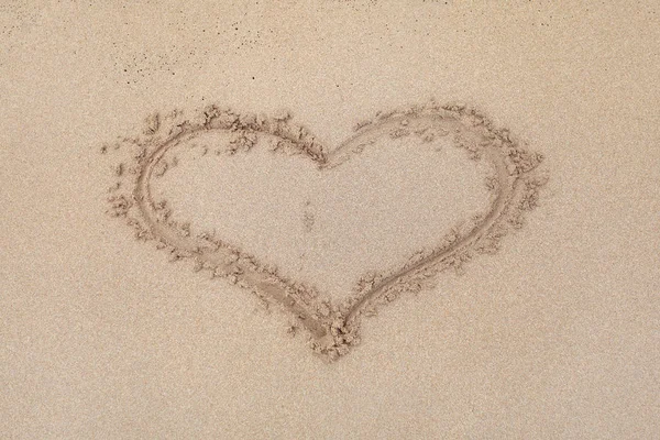 Símbolo de calor escrito en una playa de arena húmeda . — Foto de Stock