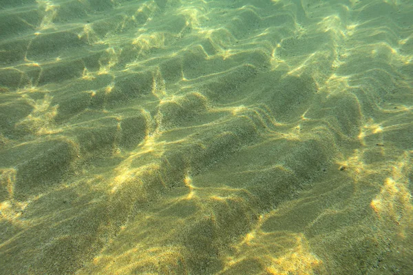 Onderwater foto - zon schijnt op zand "duinen" op de zeebodem in sh — Stockfoto