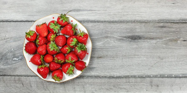 Vista da tavolo - piatto con fragole su scrivania in legno grigio, pla — Foto Stock