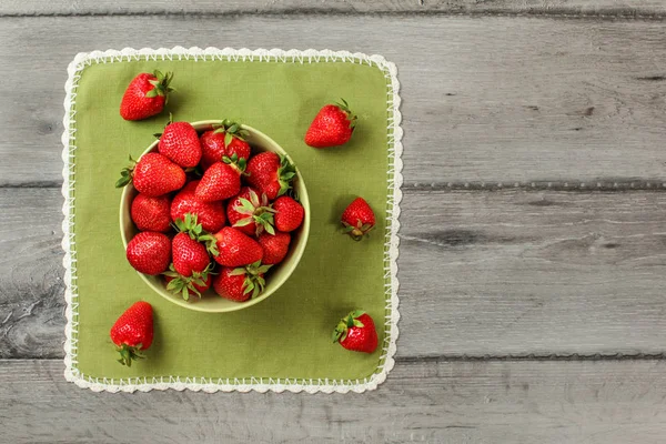 Vista laica plana - tazón pequeño con fresas, algunas derramadas en gr — Foto de Stock