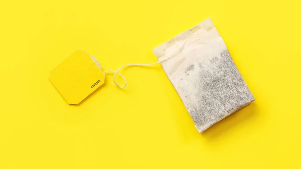 Vue du dessus, sachet de thé avec étiquette vide sur carton jaune . — Photo