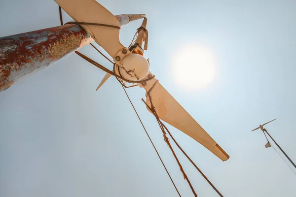 Op zoek naar kleine gebroken windturbine, sterke middagzon schijnt — Stockfoto