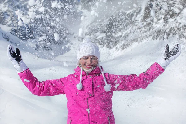 Молодая женщина в розовой лыжной куртке, перчатках и зимней шляпе, улыбаясь , — стоковое фото