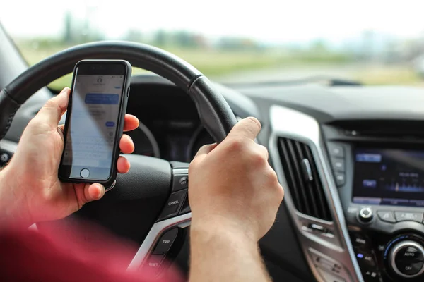 Homem verificando suas mensagens de texto durante a condução. Textos perigosos — Fotografia de Stock