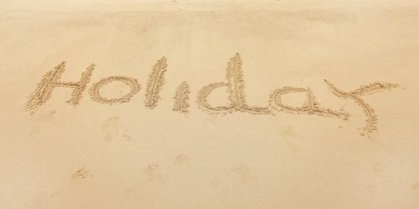 Word Holiday written on wet beach sand. — Stock Photo, Image