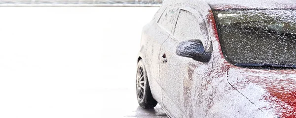 Red car washed in self serve carwash, side completely covered white foam soap, wide banner with space for text left side — Stock Photo, Image