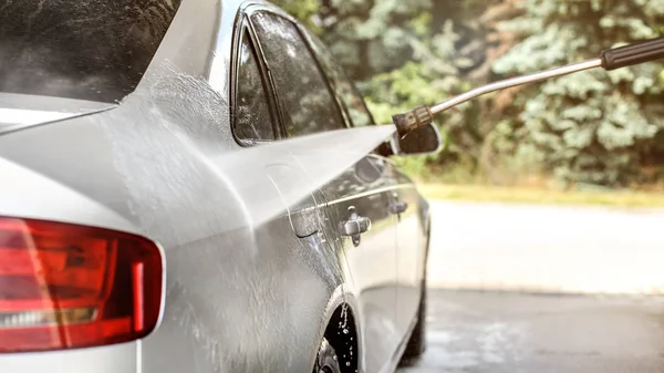 Zijde van zilveren auto gewassen in zelfbediening carwash, jet water strea — Stockfoto