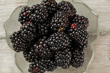 Blackberries in glass bowl, close up top down view.