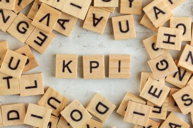Top down view, pile of square wooden blocks with letters KPI (st