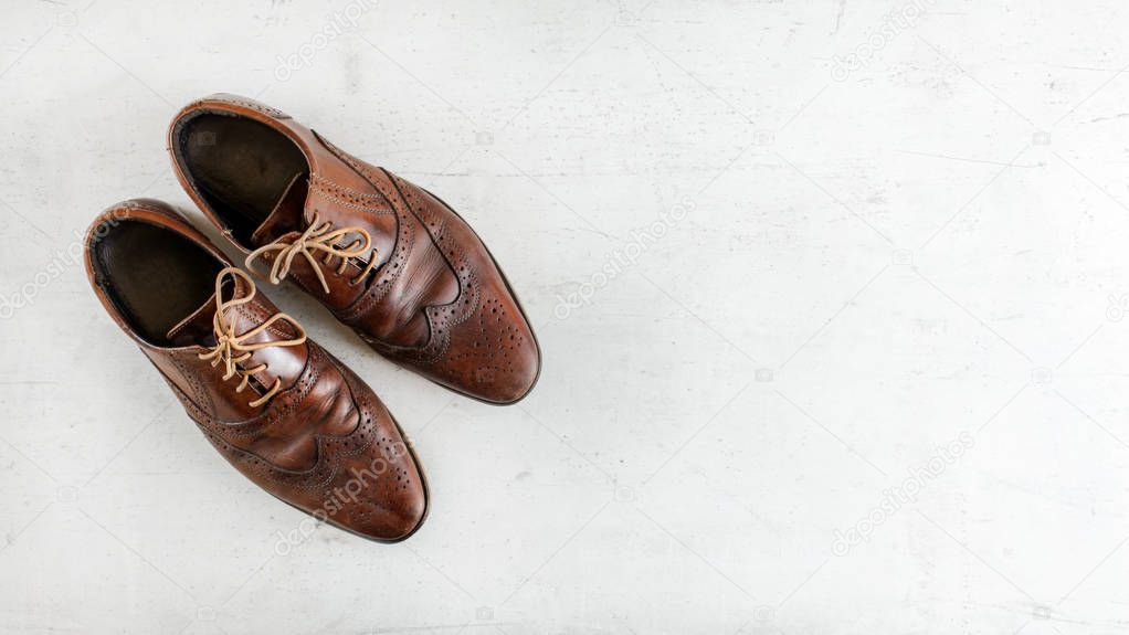 Top down view, worn classic dark brown brogue shoes on white boa