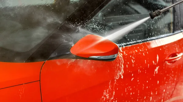 Seitenspiegel des roten Autos in Selbstbedienungs-Autowaschanlage gewaschen, Strahlwasser — Stockfoto