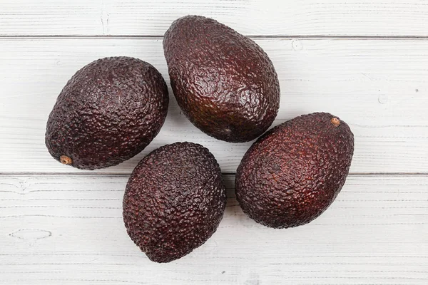 Vista da tavolo, quattro avocado maturi marrone scuro (cultivar bilse  ) — Foto Stock