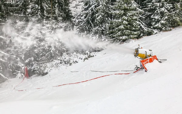 Schneeerzeuger sprüht Kunsteiskristalle über Skipiste, Schneematsch — Stockfoto