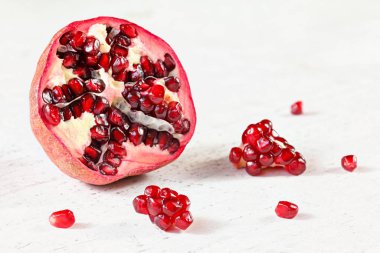 Nar da yarılır, meyveler gibi birkaç değerli şey de, beyaz çalışma tahtasına serpilmiştir..