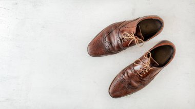 Tepeden çekimler, beyaz tahtada bir çift eskimiş kahverengi ayakkabı, mesaj bırakmak için geniş pankart