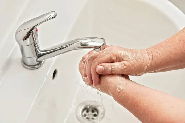 Μια Ηλικιωμένη Γυναίκα Πλένει Χέρια Της Σαπούνι Κάτω Από Βρύση — Φωτογραφία Αρχείου
