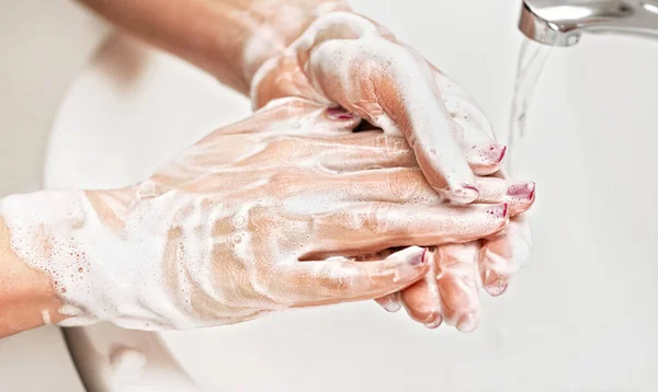 年轻妇女用肥皂在水龙头水龙头下洗手 手指上的细节 指甲上覆盖着紫色的光泽 个人卫生概念 预防禽流感爆发19 — 图库照片