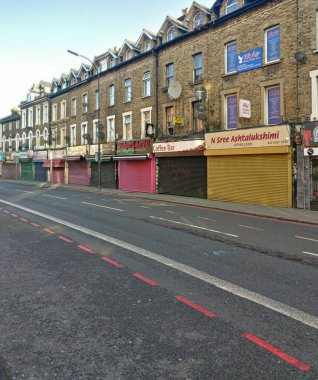 London, United Kingdom - March 31, 2020: Line of shops with shutters closed on Lee High street during coronavirus outbreak. These are usually open even on Sundays but were forced to close due to virus clipart