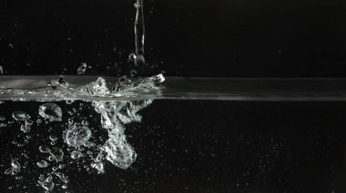 Akvaryum tankına dökülen su, siyah zemin