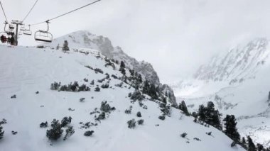 Strbske Pleso, Slovakya - 15 Mart 2019: Kayak sandalyesi kaldırma - dağın tepesinde ücretsiz yolculuk alanı, bulutlu bir günde küçük çam ağaçlarının arasına inen isimsiz kayakçı