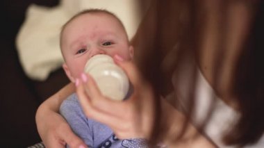 Anne bebeğini biberondan besliyor.