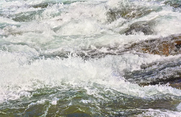 Rapid spring river fluindo sobre rochas no dia ensolarado, formando ondas de água branca, detalhe close-up - abstrato natureza fundo — Fotografia de Stock