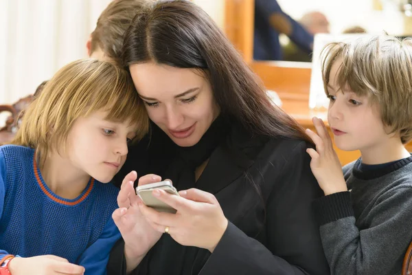 Anya és a gyerekek élvezik smartphone — Stock Fotó