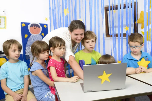 Erzieherin im Kindergarten von Kindern umgeben — Stockfoto