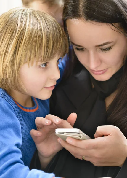 Madre e bambini godendo smartphone — Foto Stock