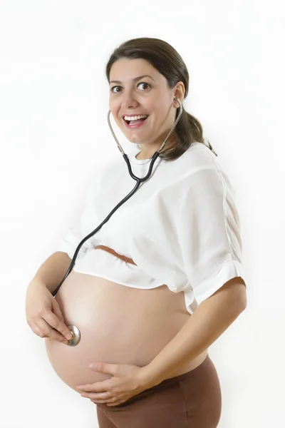 妊娠中の女性は彼女の赤ちゃんを聞く — ストック写真