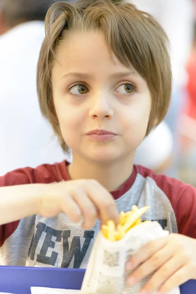Lilla pojken äta stekt potatis — Stockfoto