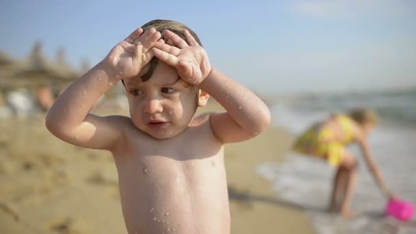 かわいい男の子だけ出て 水が冷たい 海辺に震えています — ストック動画