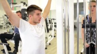 İnsanlar farklı aletleri spor salonunda egzersiz