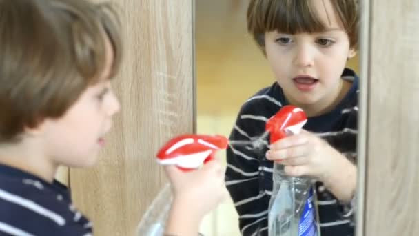 Χαριτωμένο Αστείο Μικρό Αγόρι Καθαρίζοντας Τον Καθρέφτη Χρησιμοποιώντας Σπρέι Καθαρισμού — Αρχείο Βίντεο
