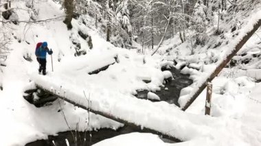 Kadın geçiş nehir günlük Köprüsü'nde dağlarda, kış