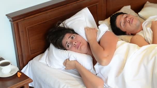 Een Vermoeide Vrouw Proberen Wat Slapen Naast Een Man Snorer — Stockvideo