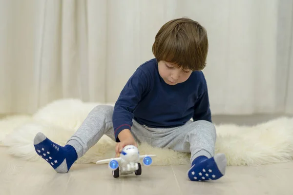 Kleiner Junge spielt mit einem Spielzeugflugzeug — Stockfoto