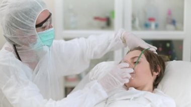 Doktor kadın küçük bir çocuğa bakıyor, onu tedavi ediyor ve entübe ediyor, yavaş çekim videosu.