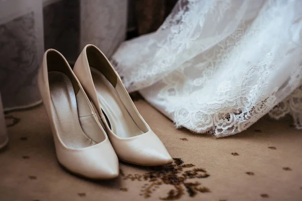 Chaussures près d'une robe de mariée — Photo