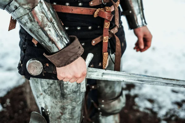 Man's hand with an iron sword — Stock Photo, Image